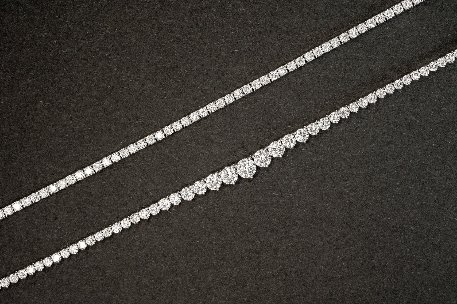 8.4 carat lab-grown tennis necklace in white gold next to 12 carat lab-grown white gold graduated diamond infinity tennis necklace